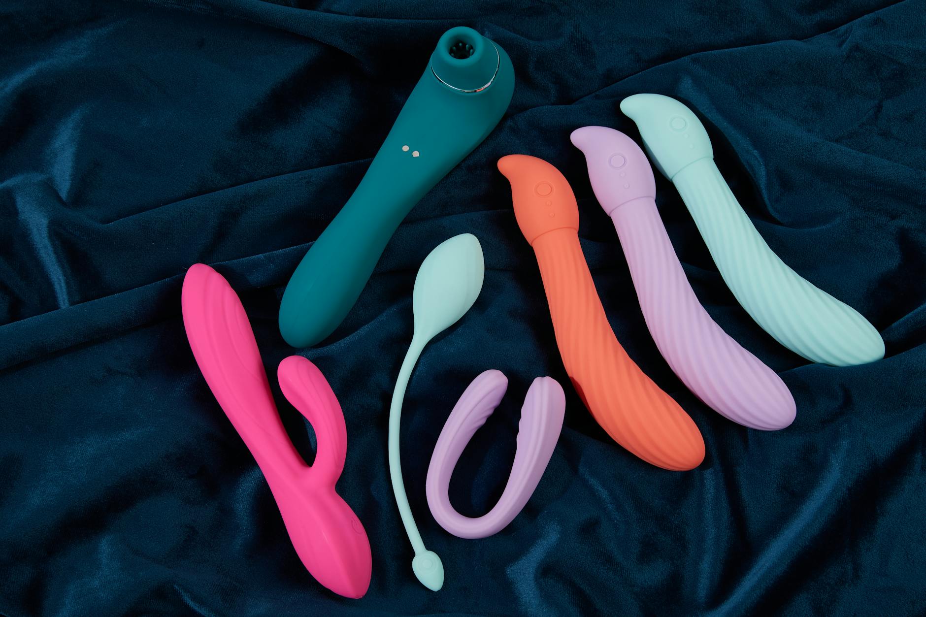 Yellow silicone vibrator surrounded by peeled bananas on yellow background
