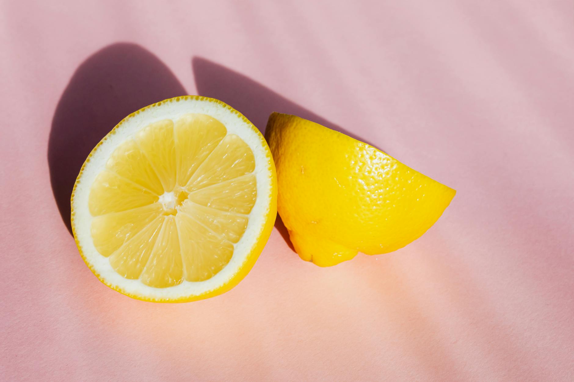 Fresh lemons on a pink background in bright sunlight