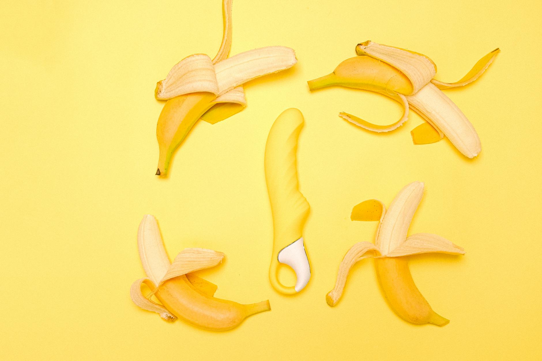 A yellow lemon vibrator surrounded by fresh peeled lemons on a bright yellow background, symbolizing renewed desire and natural pleasure.