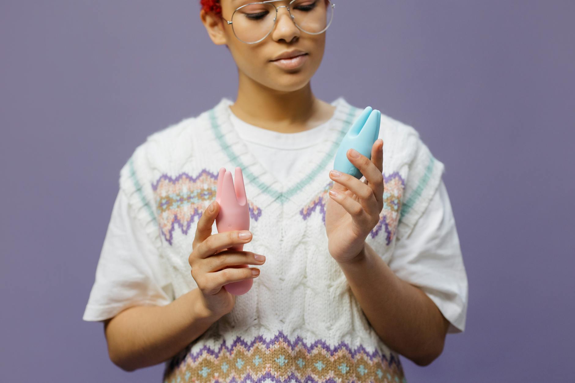 Woman holding silicone vibrators, representing postpartum pleasure exploration